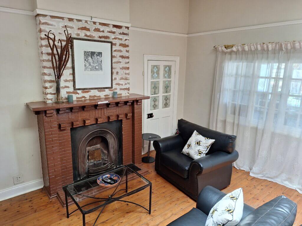 Oude Post Guesthouse - Main House Lounge showing the fireplace